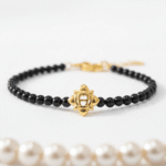 ✨ انسياب الأناقة: سوار AIGNER بتوقيع العقيق الأسود والذهب ✨